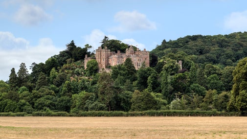Exterior of Dunster Castle, Somerset, from the main road on a day with blue skies.